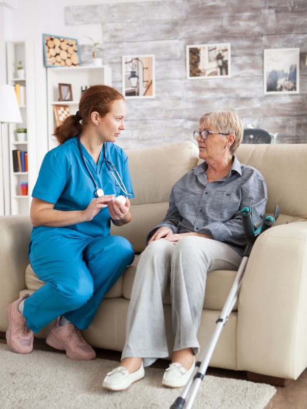 female-nurse-sitting-on-couch-with-senior-woman-3.jpg